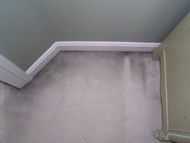 Carpet with black edges along the baseboards.
