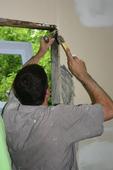 Dave hammering the wood shim to make the new window fit.