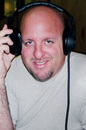 Jim with headphones being interviewed by a sports radio show to discuss 'the art of tailgating'