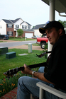 Mike at twilight playing guitar on the porch.
