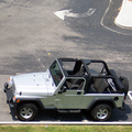 A parked Jeep Wrangler Unlimited with the soft top down.