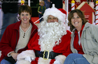Suzie and Lynnette sitting with Santa in the mall.