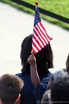 A toddler in the audience waving and American flag.