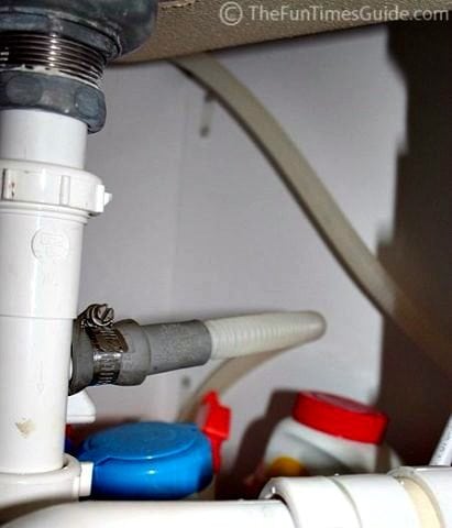 A look under our sink where the drain hose from the dishwasher is seen here, clamped. 