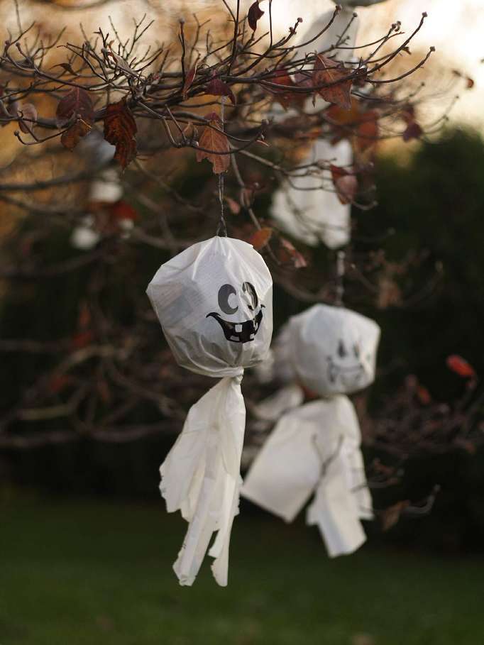 Here's a fun way to make little white ghosts for your outdoor DIY Halloween trees... use old white plastic bags instead of white sheets or white pieces of cloth.