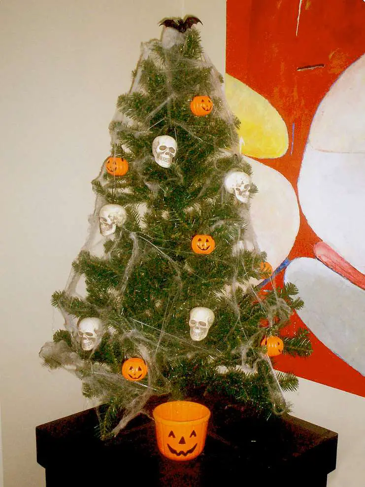 A simple DIY Halloween Christmas tree made from a small artificial Christmas tree -- with Halloween decorations and Halloween spider webs!