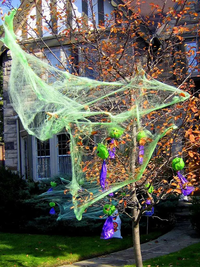 Simple Halloween webbing or Halloween spider webs can easily be added to a live tree outside in the yard once the leaves have begun to turn orange during the autumn months.