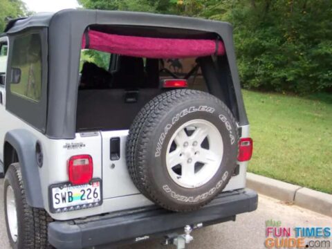 Using a towel to protect the Jeep Wrangler rear window from scratches while being rolled up. 
