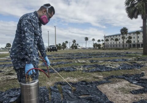 U.S. Navy applying permethrin spray to military uniforms